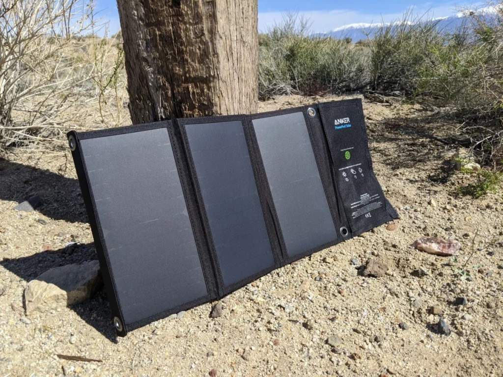 Les Chargeurs solaires portables Anker PowerPort Solar 21W présenté sur une surface, montrant ses panneaux solaires et ses ports USB.