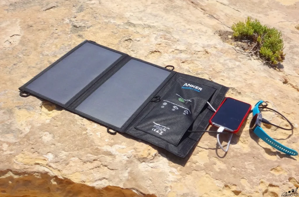 Panneaux solaires Anker posés sur un rocher, rechargeant un téléphone avec l'énergie solaire en extérieur